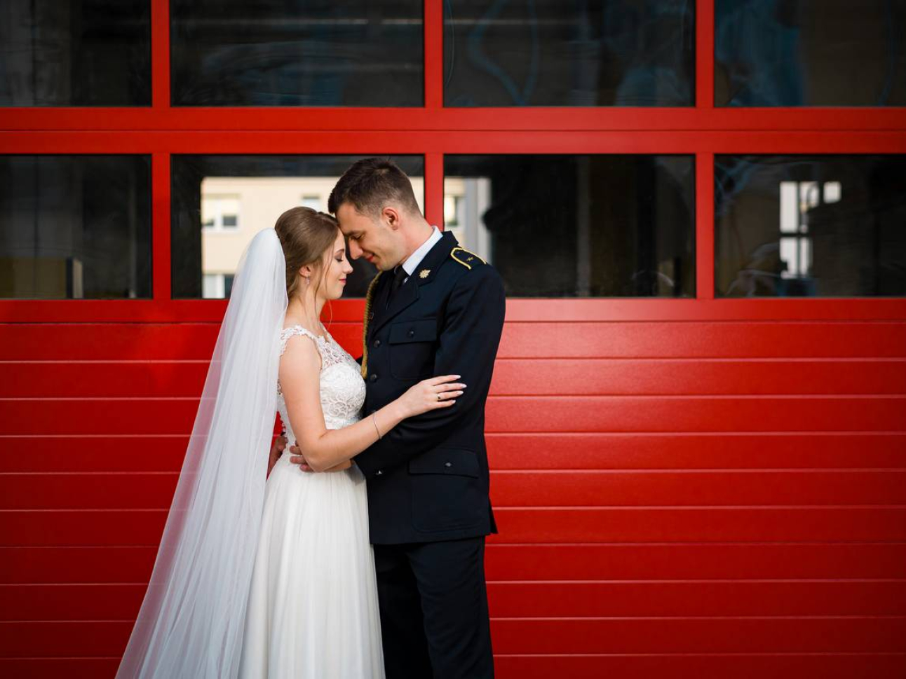 Para Młoda na tle czerwonych drzwi straży pożarnej