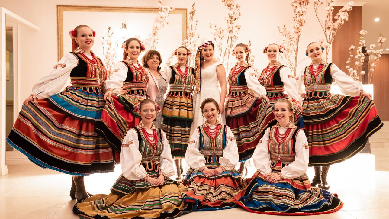 Folkowe wesele Zdjęcie grupowe na którym jest Panna Młoda i ubrane na ludowo koleżanki z zespołu ludowego