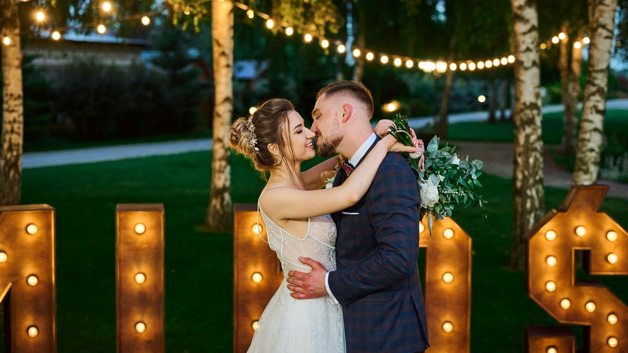 Rustykalne wesele w Dworku Diana w Białej Podlaskiej Całująca się para młoda na tle napisu miłość